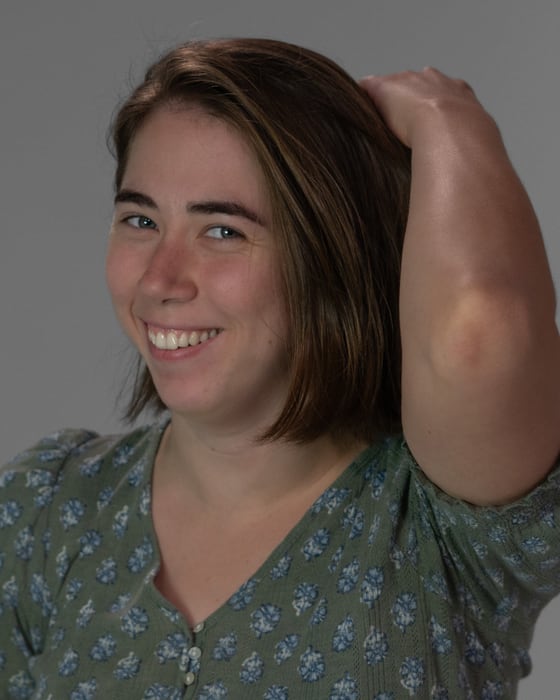 Cynthia Babecka laughing, one hand pushing her hair back