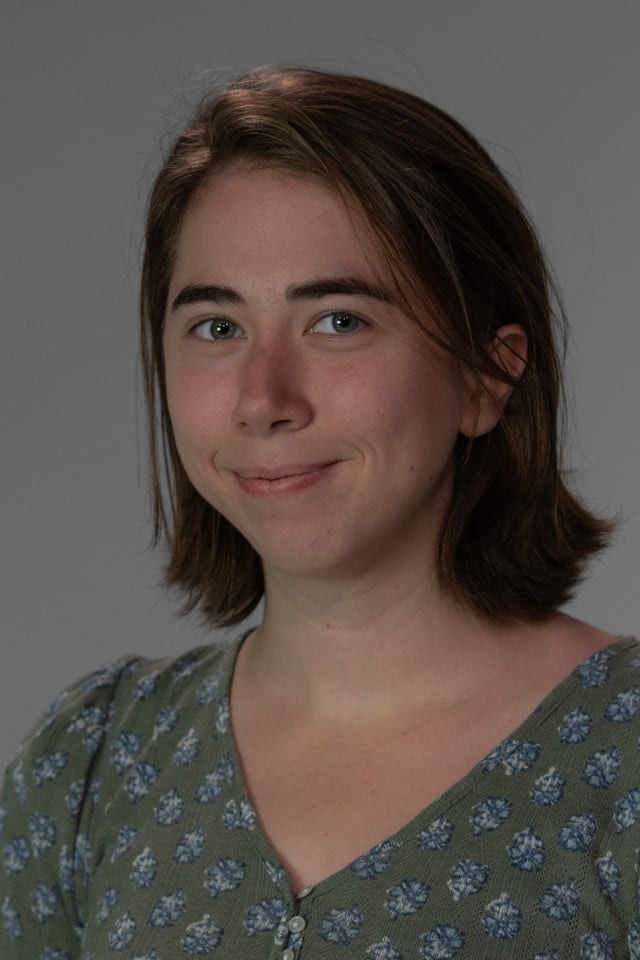 Cynthia Babecka in a studio portrait, turned slightly to one side and smiling